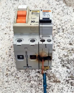 Disjoncteur électrique fondu et fil carbonisé suite à une connexion desserrée dans un tableau électrique